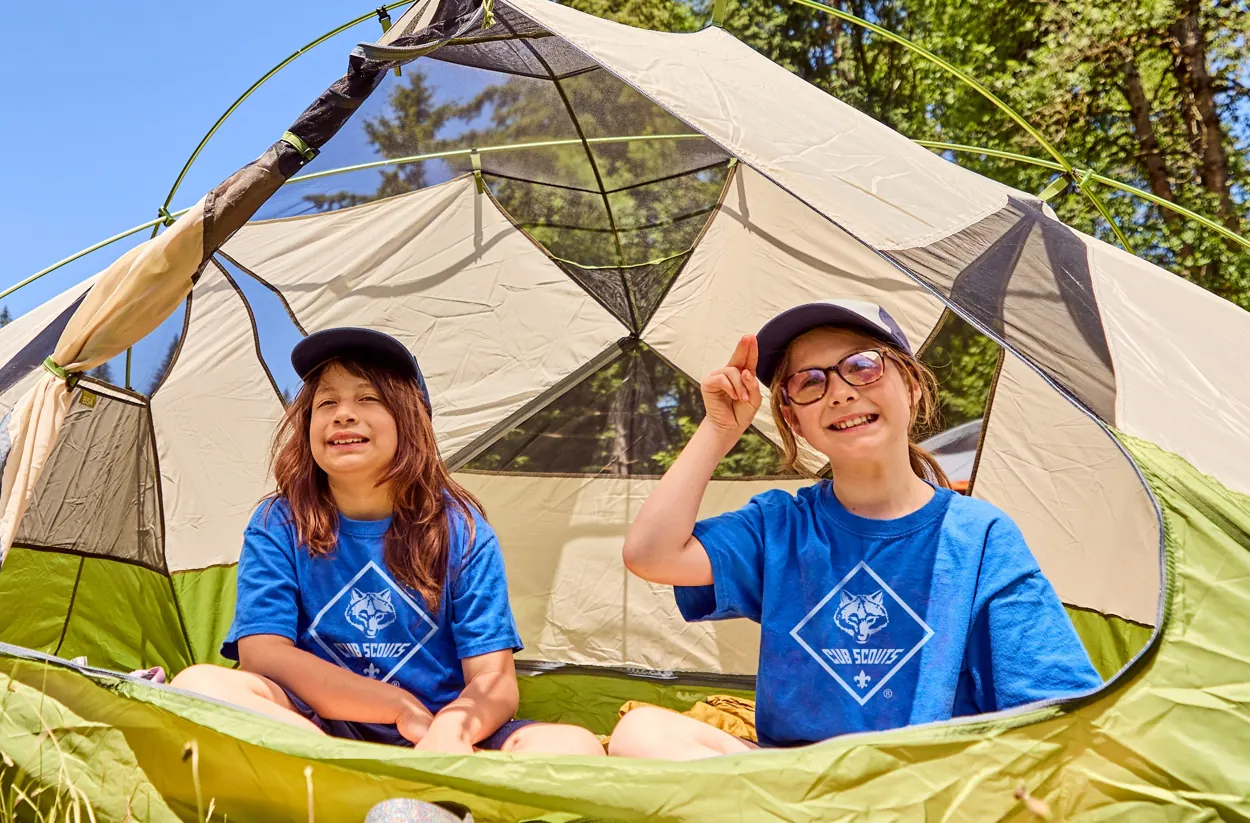 Cub Scouts smiling together at a campsite